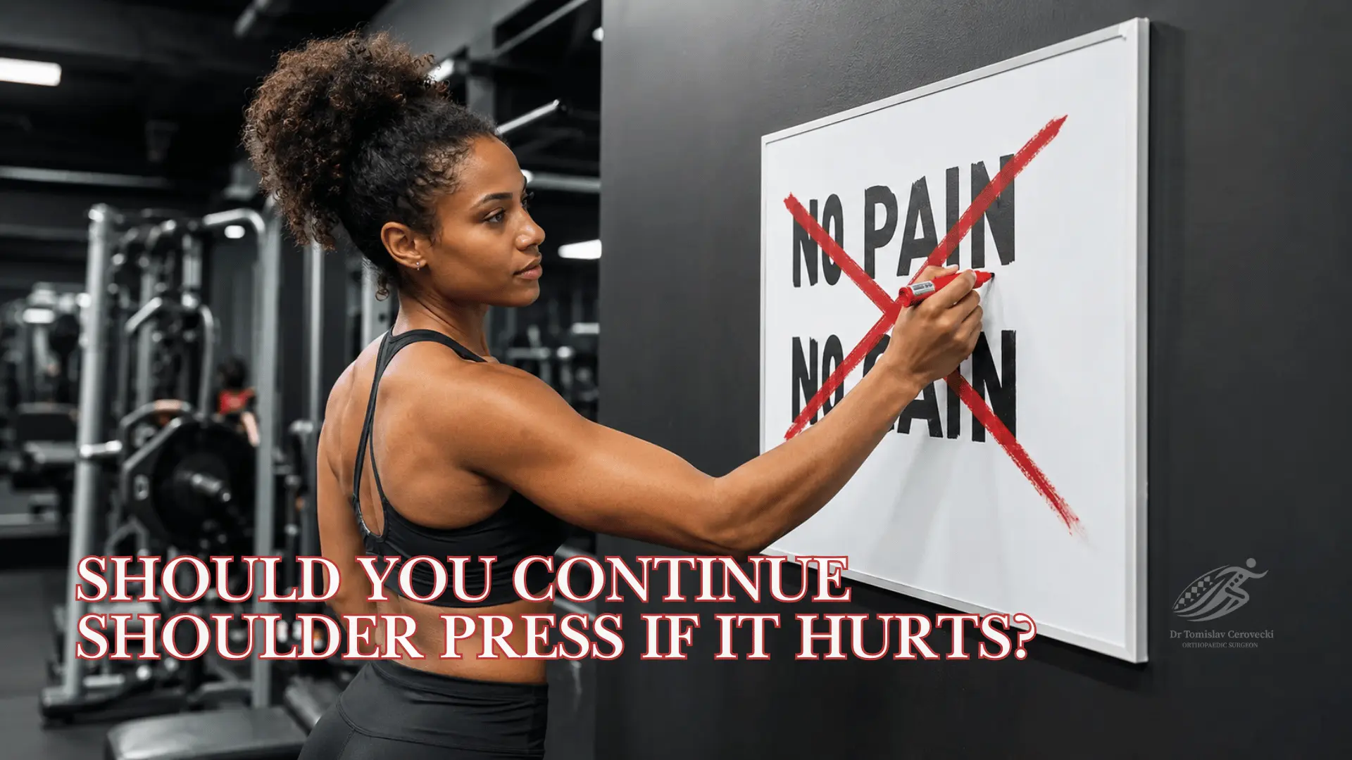 Athlete pausing shoulder press exercise because of shoulder pain, illustrating when training should be modified or assessed.